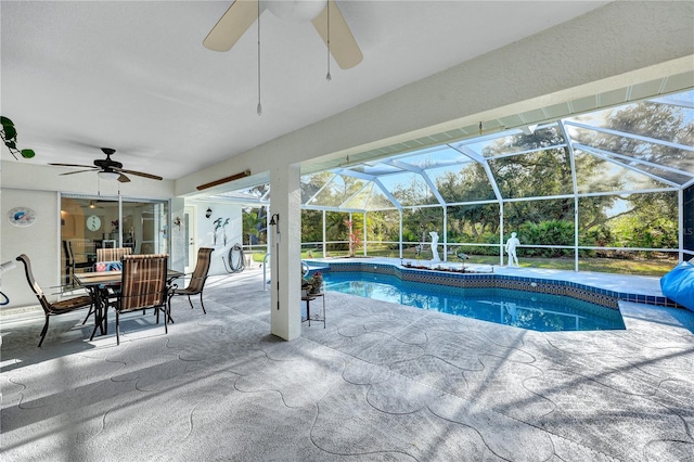 outdoor pool with glass enclosure, a patio area, and ceiling fan