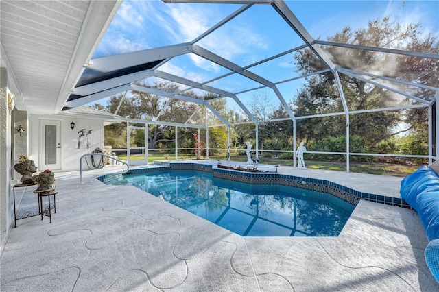 outdoor pool with glass enclosure and a patio area