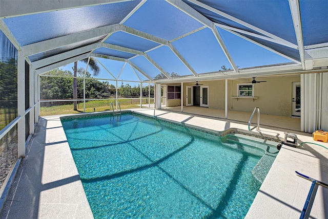 pool with glass enclosure, a ceiling fan, and a patio