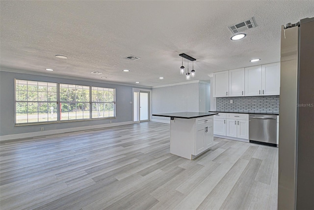 kitchen with dark countertops, visible vents, backsplash, open floor plan, and dishwasher