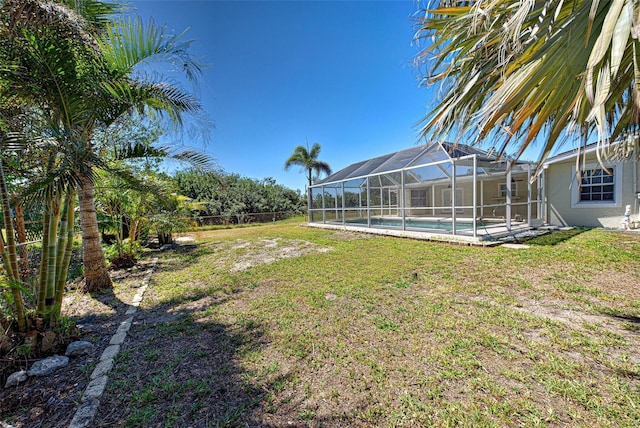 view of yard with glass enclosure, an outdoor pool, and fence