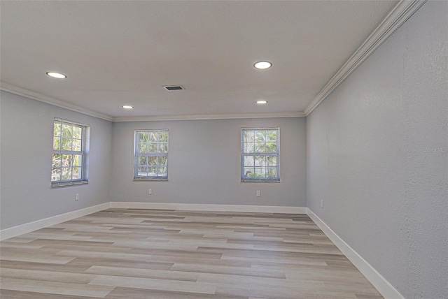 unfurnished room with baseboards, plenty of natural light, and crown molding