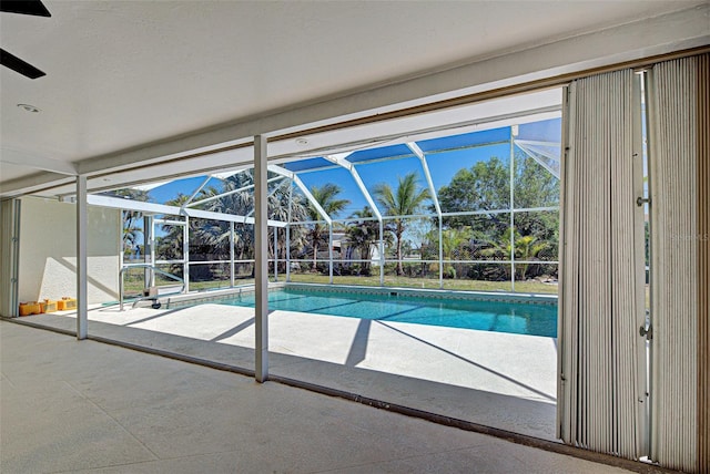 outdoor pool with glass enclosure and a patio