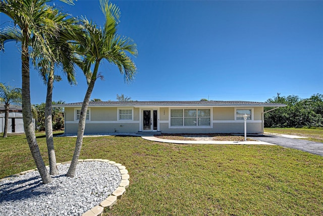 ranch-style home featuring stucco siding, french doors, and a front yard