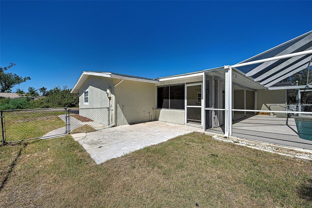 rear view of property with a patio area, fence, a lawn, and stucco siding