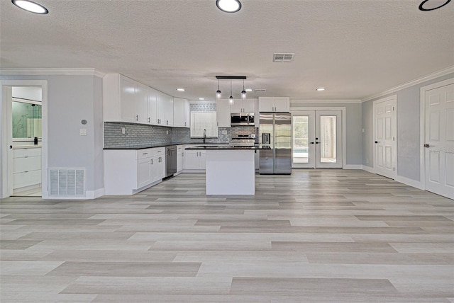 kitchen with dark countertops, backsplash, visible vents, and appliances with stainless steel finishes