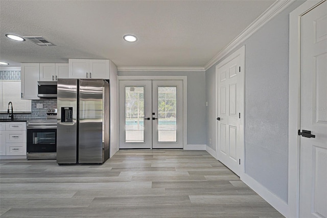 kitchen featuring visible vents, tasteful backsplash, stainless steel appliances, french doors, and crown molding