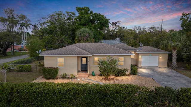 ranch-style house with a garage, fence, and concrete driveway