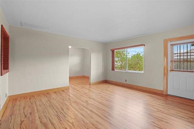 spare room with visible vents, a healthy amount of sunlight, light wood-style flooring, and baseboards