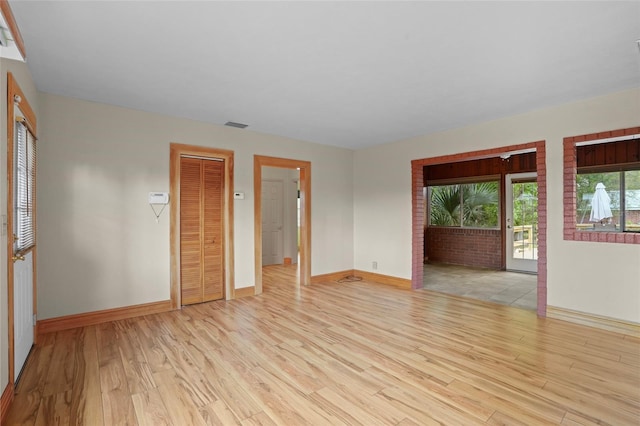 empty room featuring baseboards and light wood-style floors