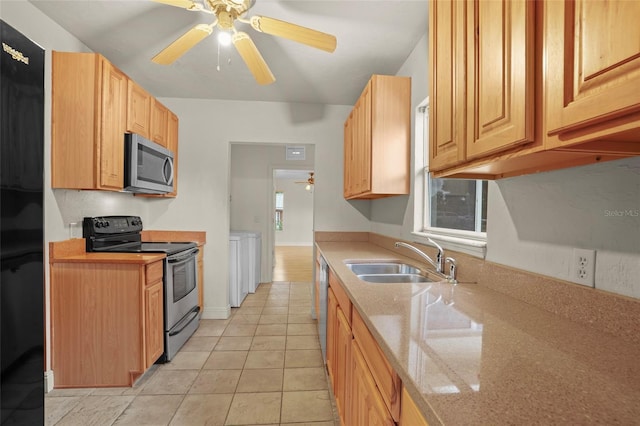 kitchen featuring appliances with stainless steel finishes, a sink, light stone counters, and ceiling fan