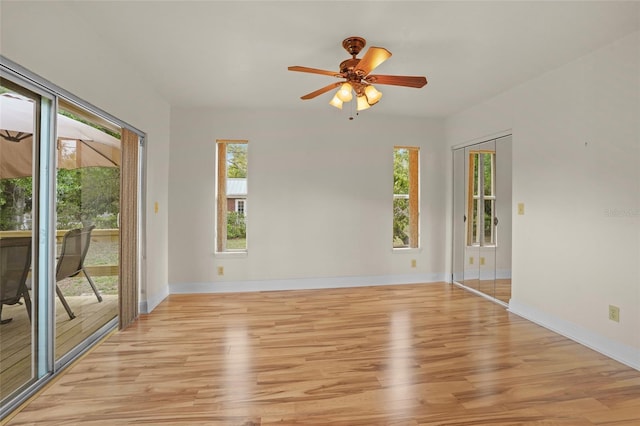 empty room with a healthy amount of sunlight, light wood finished floors, and baseboards