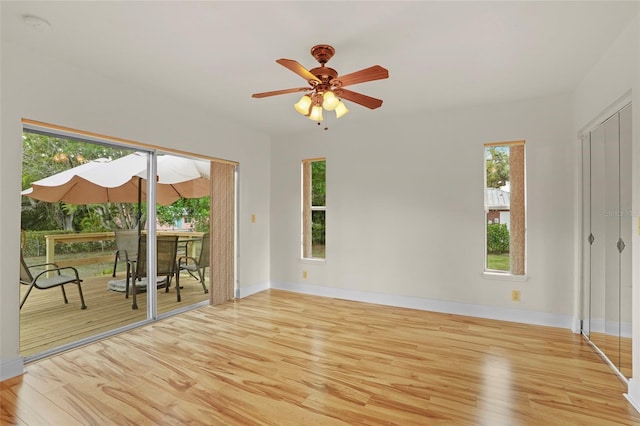 empty room with ceiling fan, baseboards, and wood finished floors