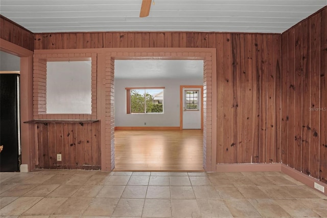 unfurnished room featuring wood walls