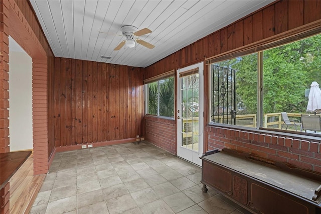 unfurnished sunroom with a ceiling fan and wood ceiling