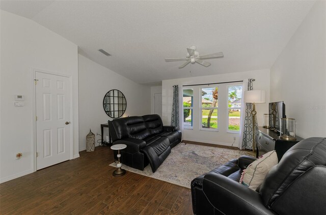 living room featuring dark wood finished floors, lofted ceiling, visible vents, ceiling fan, and baseboards