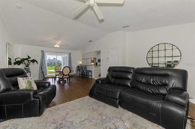 living area featuring visible vents, a ceiling fan, vaulted ceiling, a textured ceiling, and wood finished floors