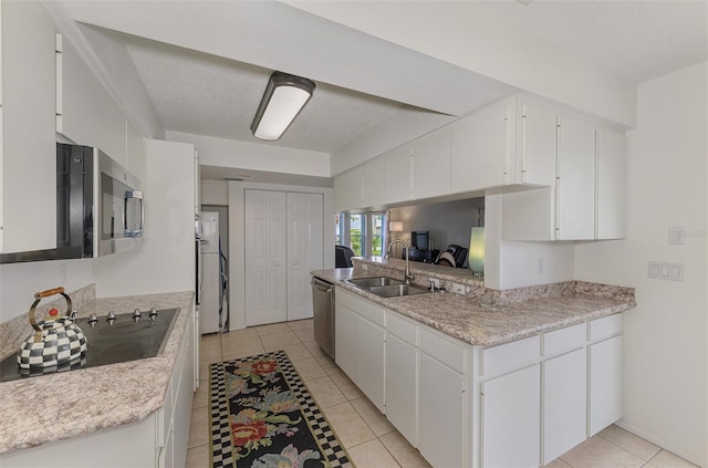 kitchen featuring light countertops, appliances with stainless steel finishes, a sink, and white cabinetry