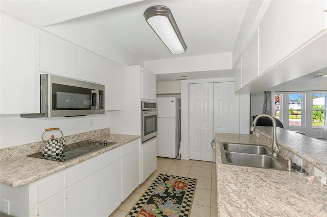 kitchen featuring light countertops, appliances with stainless steel finishes, a sink, and white cabinets