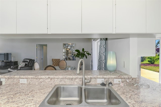 kitchen with light countertops, modern cabinets, a sink, and white cabinetry