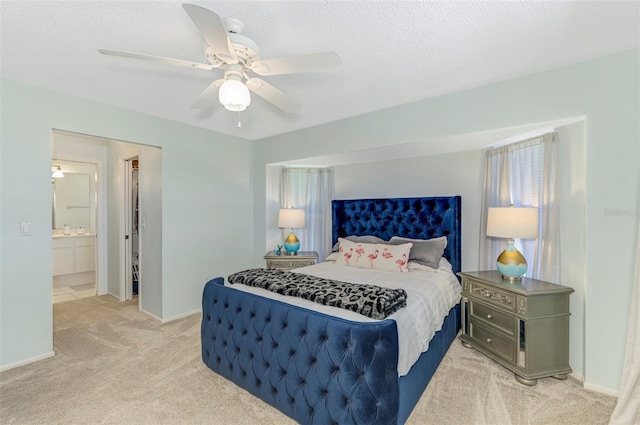 bedroom featuring light colored carpet, a textured ceiling, and baseboards