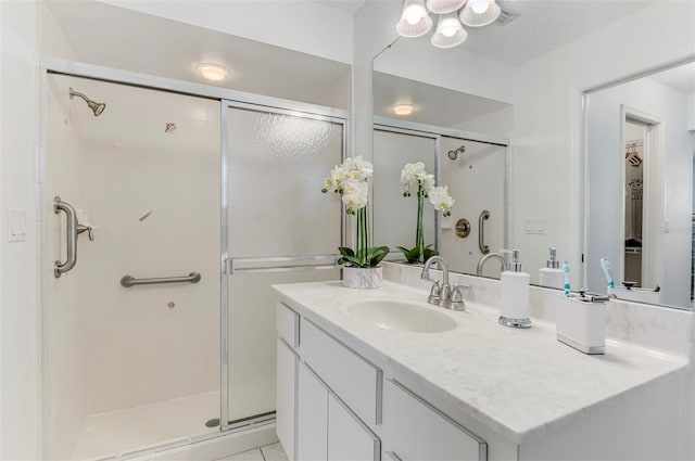 bathroom with a shower stall and vanity