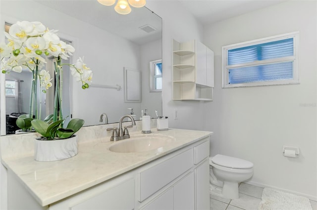 bathroom featuring toilet, vanity, baseboards, visible vents, and tile patterned floors