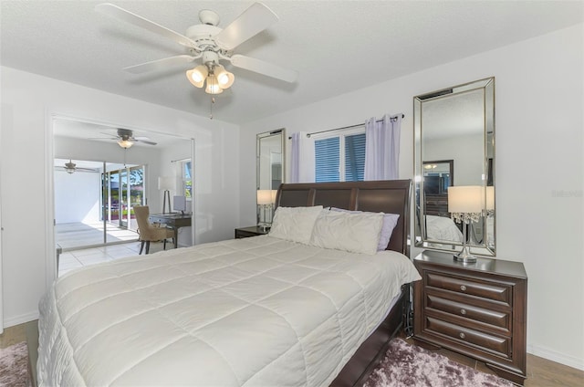 bedroom featuring baseboards, ceiling fan, wood finished floors, access to exterior, and a textured ceiling