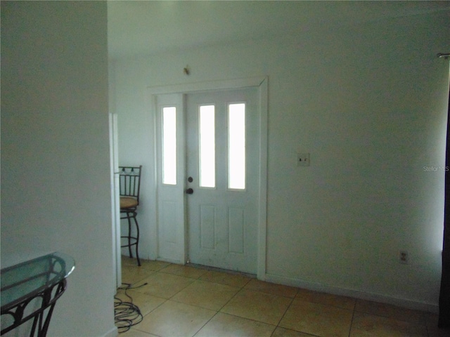 entrance foyer with light tile patterned floors and baseboards