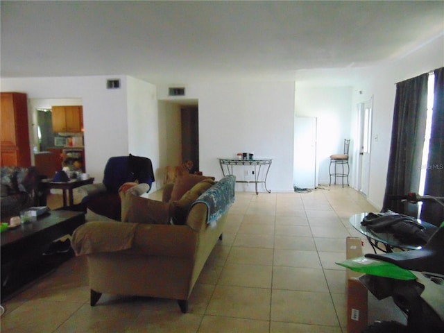 living area with light tile patterned floors and visible vents