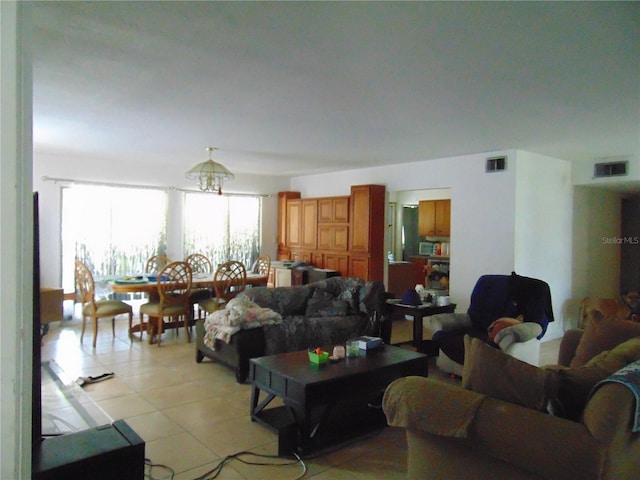 living area with light tile patterned flooring and visible vents