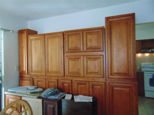 kitchen featuring electric range and brown cabinets