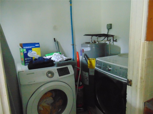 washroom with laundry area, water heater, and washer and clothes dryer