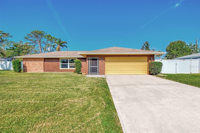 ranch-style house featuring an attached garage, driveway, fence, and a front lawn