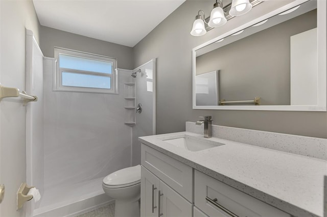 bathroom featuring a walk in shower, vanity, and toilet