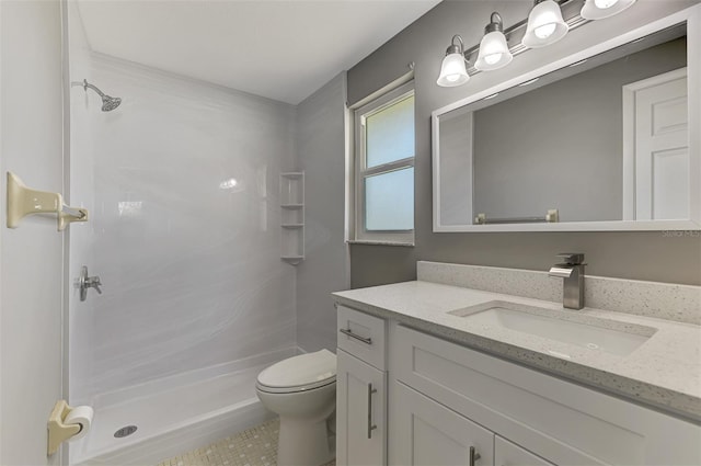 full bathroom featuring toilet, a stall shower, and vanity