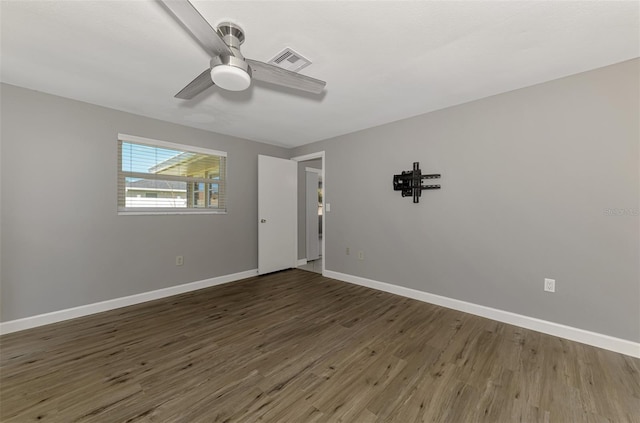 empty room featuring visible vents, ceiling fan, baseboards, and wood finished floors