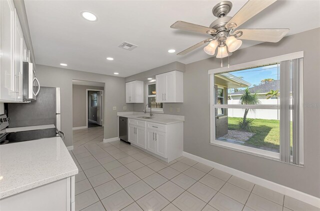 kitchen featuring appliances with stainless steel finishes, light tile patterned floors, visible vents, and white cabinetry