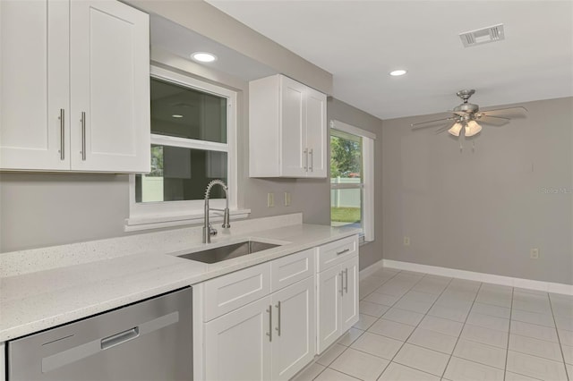 kitchen with baseboards, visible vents, white cabinets, stainless steel dishwasher, and a sink