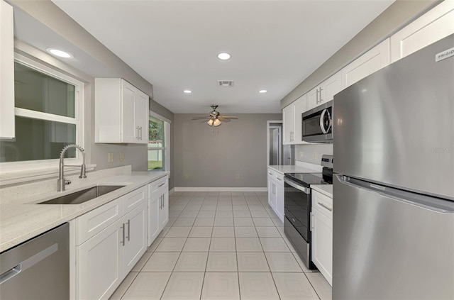 kitchen featuring ceiling fan, stainless steel appliances, a sink, visible vents, and white cabinetry