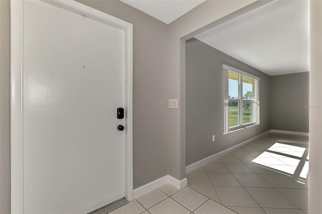 foyer featuring baseboards and light tile patterned floors