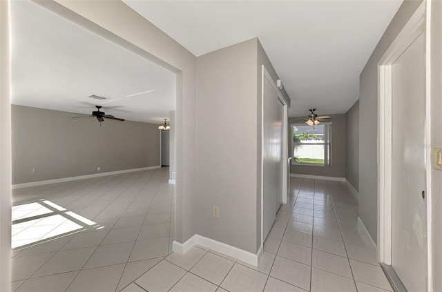 hallway with visible vents, baseboards, and light tile patterned flooring