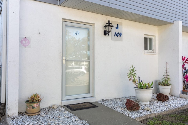 entrance to property featuring stucco siding