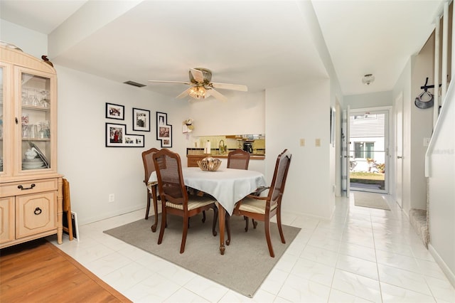 dining room with baseboards, visible vents, and ceiling fan