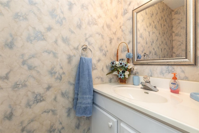 bathroom with vanity and wallpapered walls