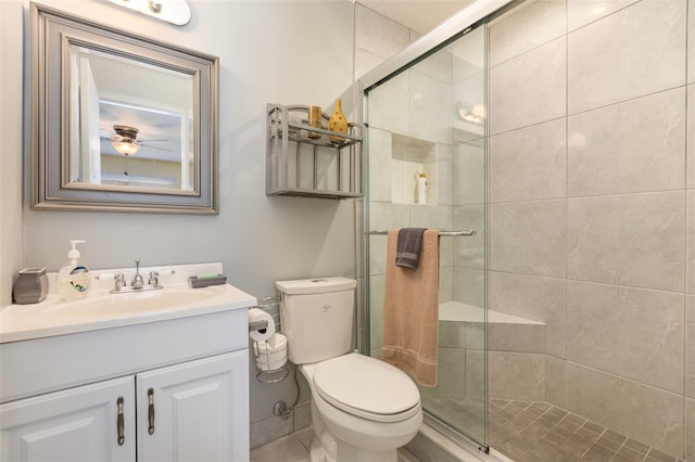 full bathroom featuring a stall shower, toilet, and vanity