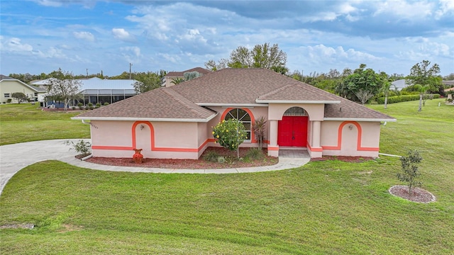 view of front facade featuring a shingled roof, a front yard, and stucco siding