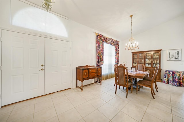 dining space with a chandelier, light tile patterned floors, and vaulted ceiling