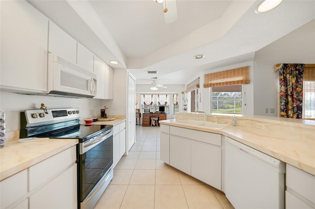 kitchen with light tile patterned flooring, white appliances, a ceiling fan, white cabinetry, and light countertops