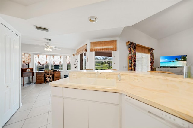 kitchen featuring dishwasher, vaulted ceiling, a sink, and visible vents